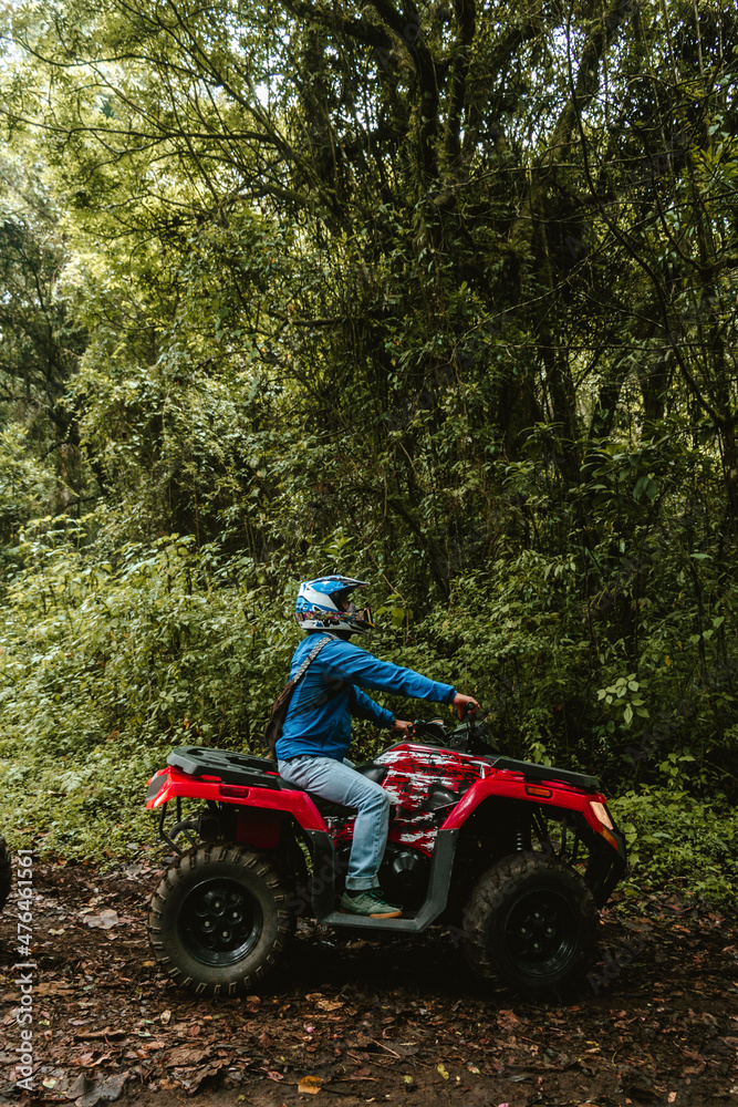 Hombre latino en cuatri moto en medio del bosque Hombre latino en cuatri moto en medio del bosque