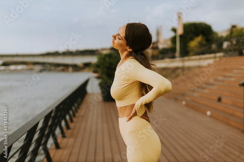 Young woman having stretching exercise on the riverside pier © BGStock72