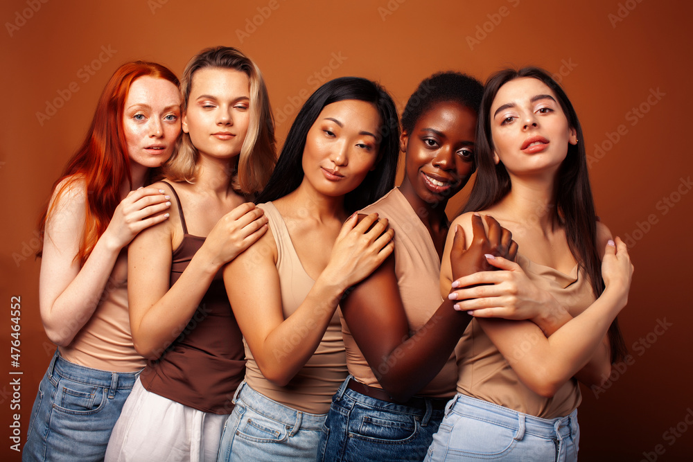 young pretty caucasian, afro, scandinavian woman posing cheerful together on brown background, lifestyle diverse nationality people concept young pretty caucasian, afro, scandinavian woman posing cheerful together on brown background, lifestyle diverse nationality people concept