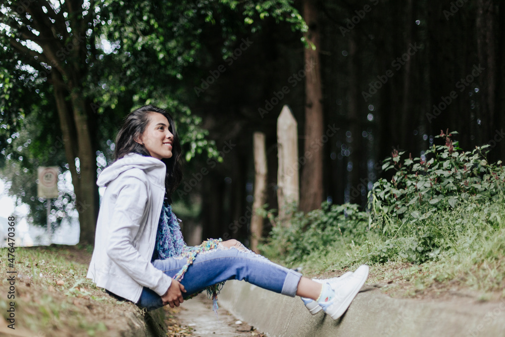 Mujer joven con pelo largo sonriendo en bosque Mujer joven con pelo largo sonriendo en bosque