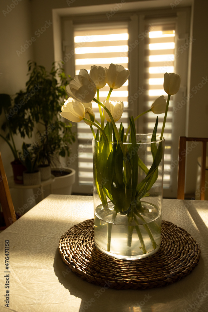 Spring flowers - white tulips in glass vase on wooden table Spring flowers - white tulips in glass vase on wooden table