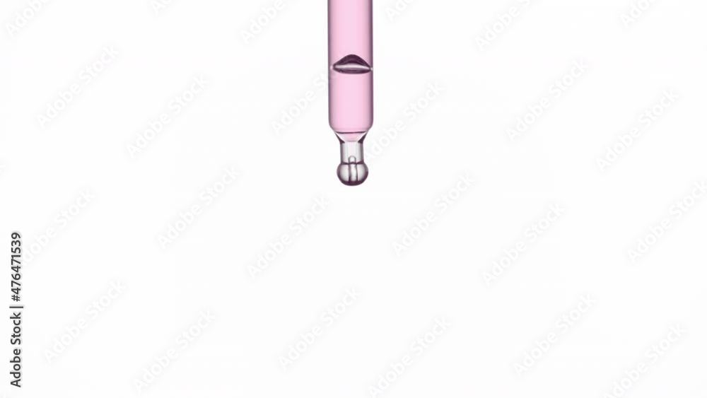 Macro shot of pink drop is falling down from chemical dropper on white background | Abstract face care lotion ingredients formulating concept