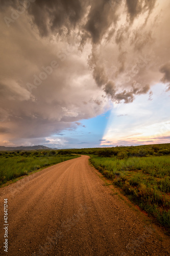 Dirt road in Arizona countryside with ominous dark monsoon clouds