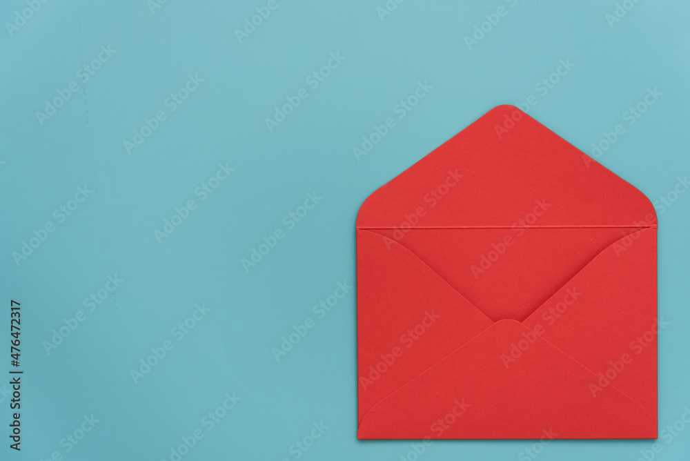 An open red envelope on a blue background. There's room for text. Stylish Valentine's Day card. Declaration of love. Invitation to a wedding, birthday or Christina. Passionate love. An open red envelope on a blue background. There's room for text. Stylish Valentine's Day card. Declaration of love. Invitation to a wedding, birthday or Christina. Passionate love.