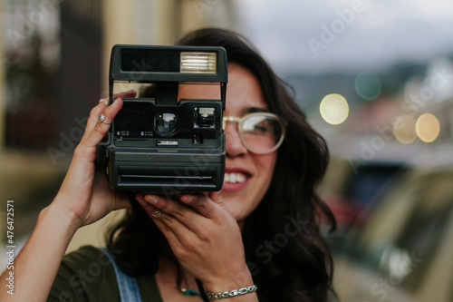 young girl with glasses and perfect teeth eating ice cream in tourist city photo