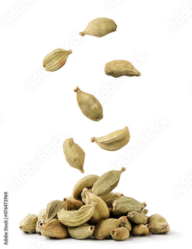 Cardamom pods fall on a pile on a white background. Isolated