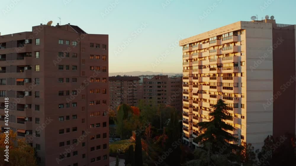 Forwards fly between and over residential houses in housing estate at golden hour. Autumn colourful foliage on trees. Forwards fly between and over residential houses in housing estate at golden hour. Autumn colourful foliage on trees.