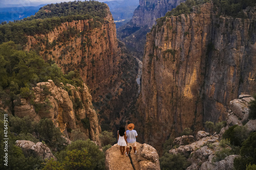 Tourist stylish couple standing on the edge of a cliff against the backdrop of a gorge. Amazing Tazi Canyon ,Bilgelik Vadisi in Manavgat, Antalya, Turkey. Greyhound Canyon, Wisdom Valley. photo