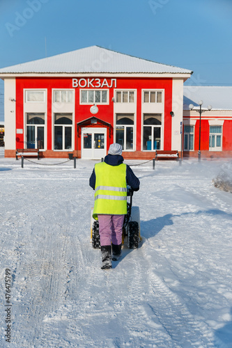 Fototapeta Naklejka Na Ścianę i Meble -  Samara, Chapaevsk, Russia-February, 20 2018: a worker removes heavy white snow with a snowplow during winter