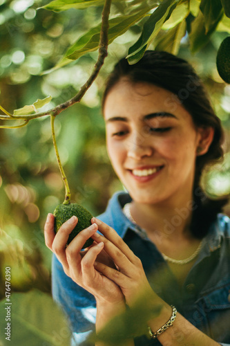 Mujer con aguacate en la mano de primera calidad photo