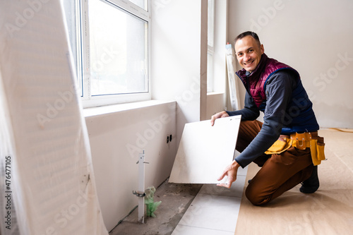 Laying Ceramic Tiles. Home tile improvement - handyman. Tiler works photo