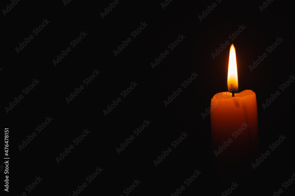 A candle burns against a dark background in the night. Mourning. A candle burns against a dark background in the night. Mourning.