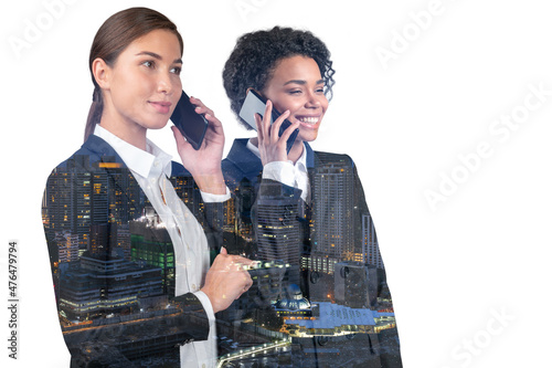 Two attractive businesswomen in suits talking phone. Asia corporate lifestyle, communication of diverse young professionals. Night Kuala Lumpur city view. Double exposure photo