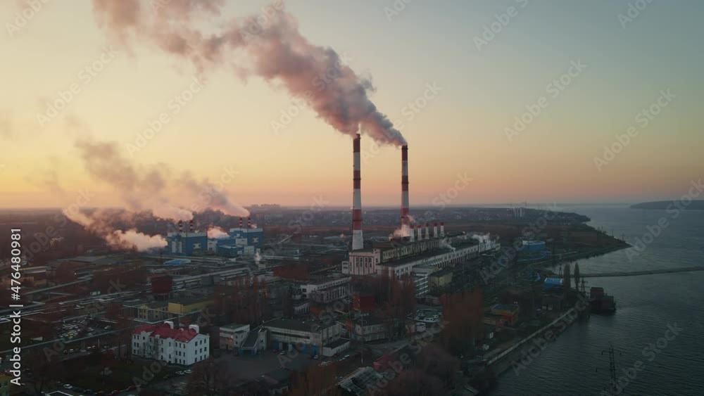 Aerial view of high smoke stack with smoke emission. Plant pipes pollute atmosphere. Industrial factory pollution, smokestack exhaust gases Aerial view of high smoke stack with smoke emission. Plant pipes pollute atmosphere. Industrial factory pollution, smokestack exhaust gases