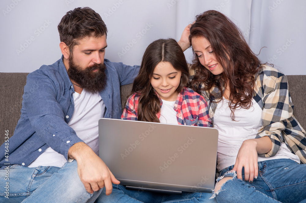 smiling family using laptop at home, education