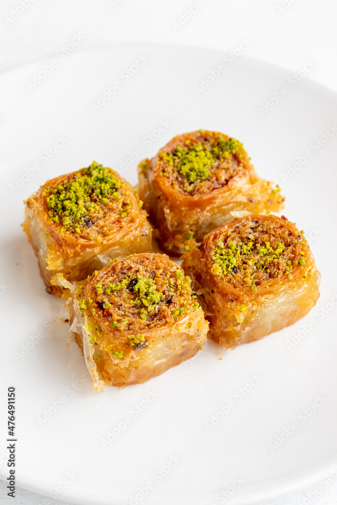 Pistachio baklava dessert on a white background. Turkish sweet dessert concept. plate of pistachio baklava. sherbet sweet Mediterranean bakery. close up. selective focus. Pistachio baklava dessert on a white background. Turkish sweet dessert concept. plate of pistachio baklava. sherbet sweet Mediterranean bakery. close up. selective focus.