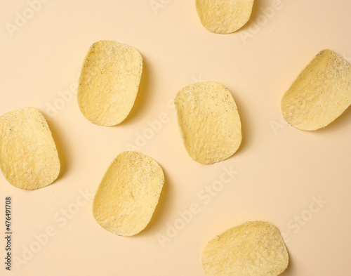 round potato chips on a beige background, top view
