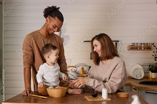 Beautiful family, in cozy brown clothes, sitting at a table in the kitchen
