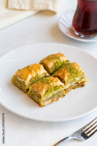 Pistachio baklava dessert on a white background. Turkish sweet dessert concept. plate of pistachio baklava. sherbet sweet Mediterranean bakery. close up. selective focus