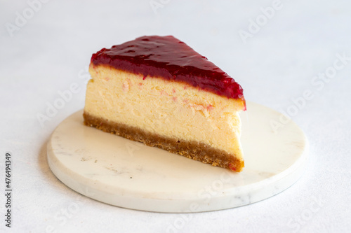 Cheesecake on white background. Greek sweet dessert concept. plate of sliced cheesecake. Cheesecake with raspberry gel filling. Mediterranean bakery. close up. selective focus. Horizontal view.
