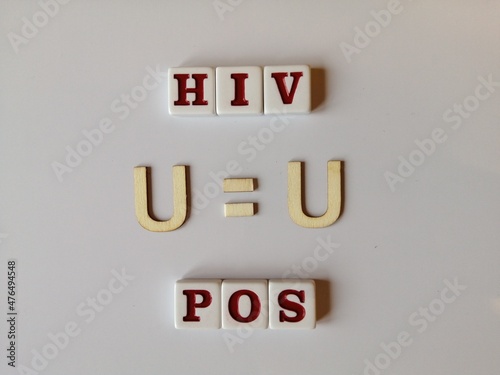 HIV Positive spelled with white and red tile with U = U in the center photo