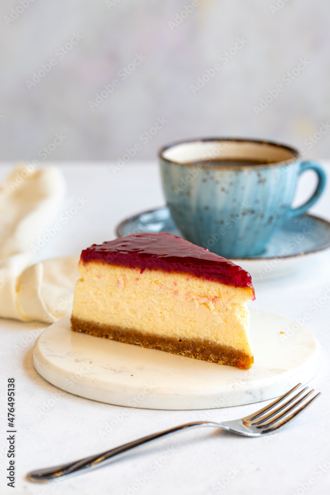 Cheesecake on white background. Greek sweet dessert concept. plate of sliced cheesecake. Cheesecake with raspberry gel filling. Mediterranean bakery. close up. selective focus. Vertical view. Cheesecake on white background. Greek sweet dessert concept. plate of sliced cheesecake. Cheesecake with raspberry gel filling. Mediterranean bakery. close up. selective focus. Vertical view.