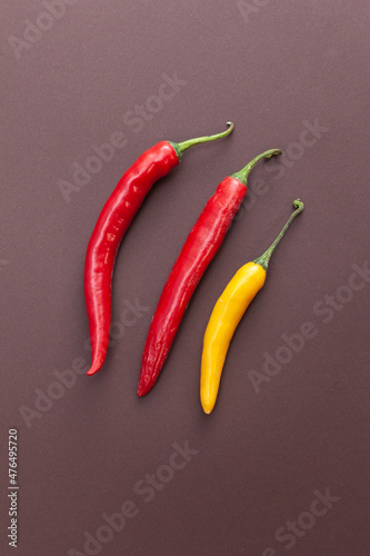 red and yellow pepper isolated on brown background