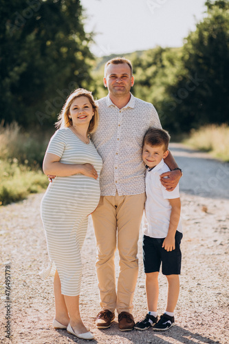 Young pregnant woman with husband and son in a forest