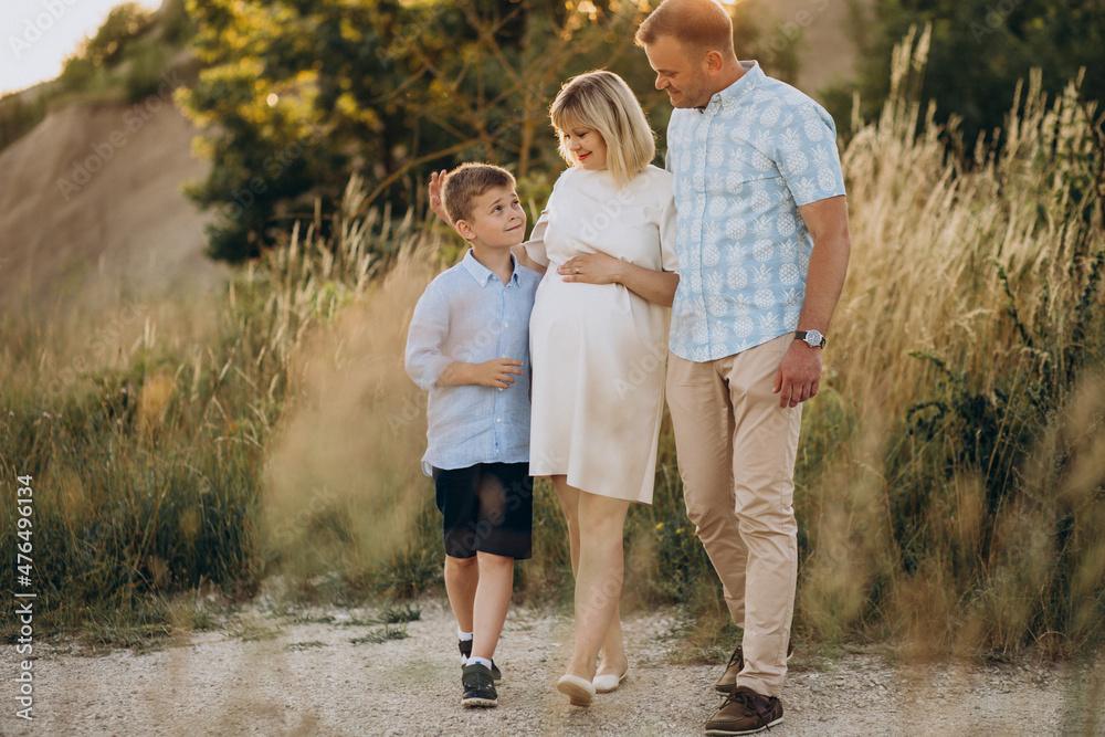 Young pregnant woman with husband and son on sunset Young pregnant woman with husband and son on sunset