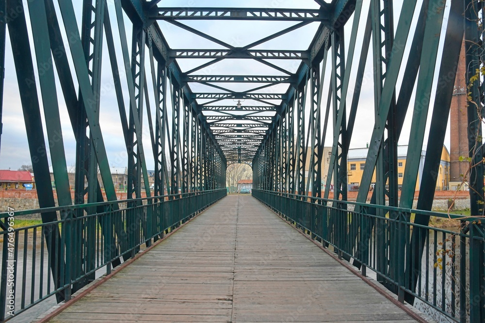 Old metal overpass, bridge over the river. Rivet metal bridge in town