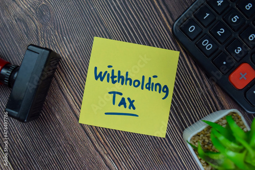 Withholding Tax write on sticky notes isolated on Wooden Table.