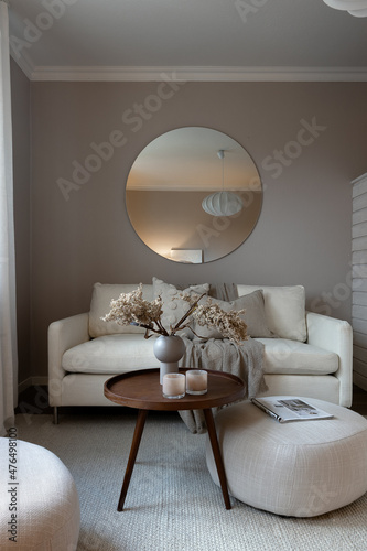 Scandinavian living room interior with round mirror on wall. 