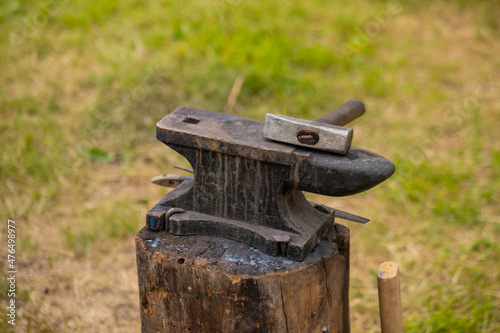Hammer and blacksmith anvil at outdoor forge, workshop - close up. Handmade, craftsmanship and blacksmithing concept