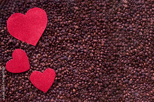 Valentine day concept with red hearts and coffee beans on wooden table with copyspace.Coffee beans and heart in the coffee lover concept