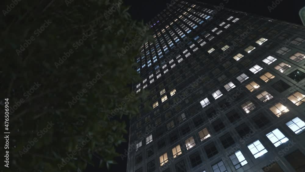 A low angle view of a high-raise building at night. A low angle view of a high-raise building at night.