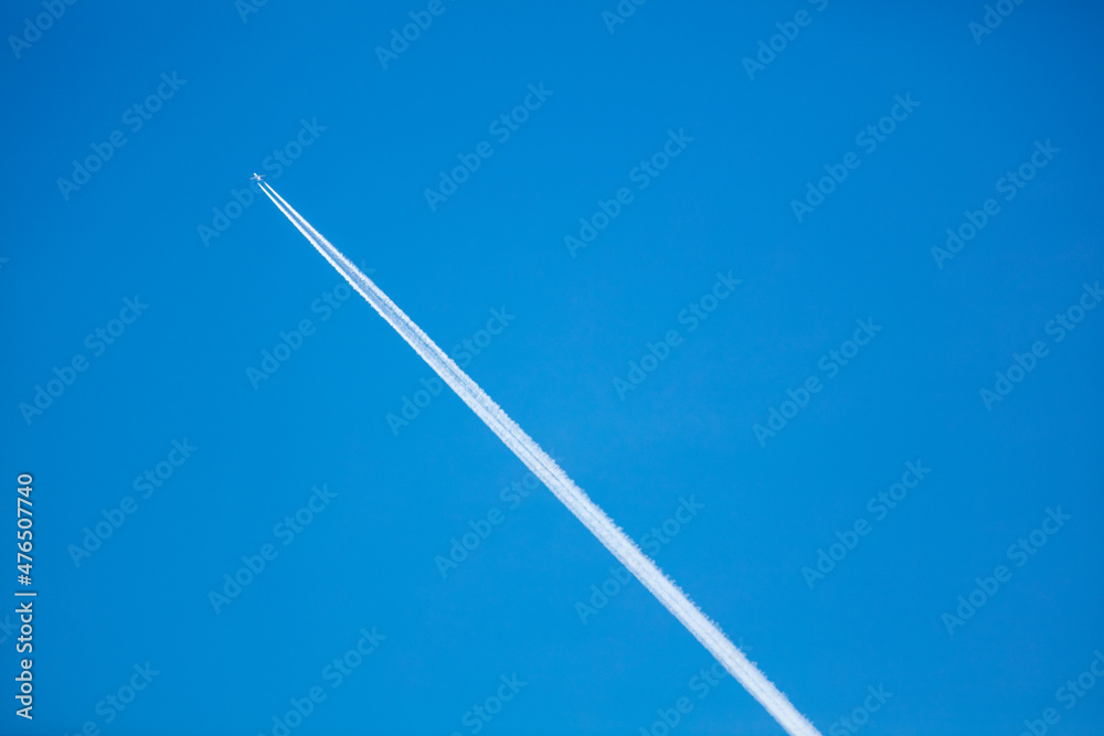 The Contrail from a High Flying Airliner Leaving a Cloud Streak in a Blue Sky as the Hot Steam Quickly Condenses as it Leaves the Engines The Contrail from a High Flying Airliner Leaving a Cloud Streak in a Blue Sky as the Hot Steam Quickly Condenses as it Leaves the Engines