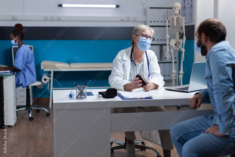 Obraz premium Woman doctor giving bottle of pills to patient for healing treatment at checkup visit. Physician holding jar with medicine to give prescription antibiotic to man at examination appointment.