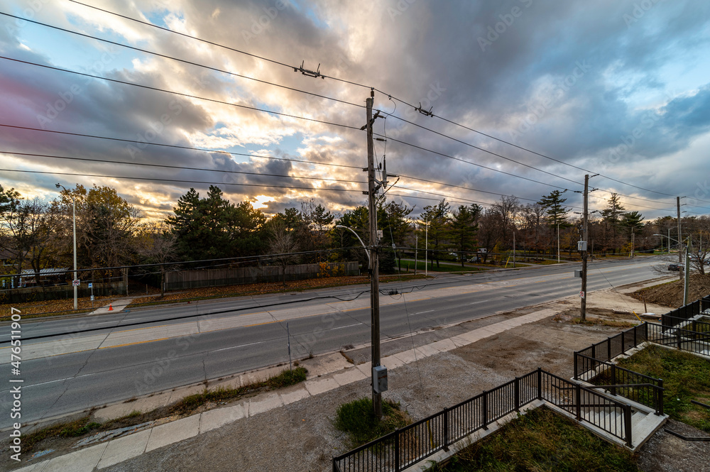 Oakville street during sunset with trees and street in view also electrical wires 