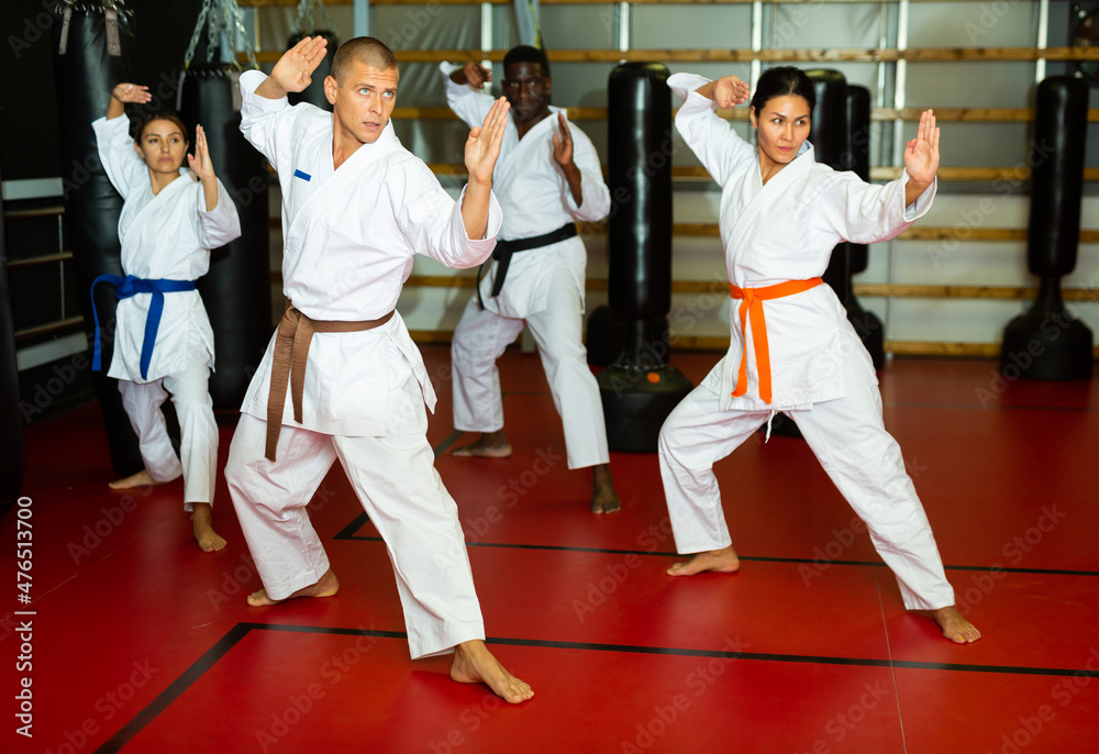 Karate or taekwondo training athletes in kimono stand in a fighting