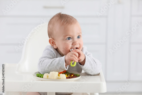 Cute little baby eating healthy food at home