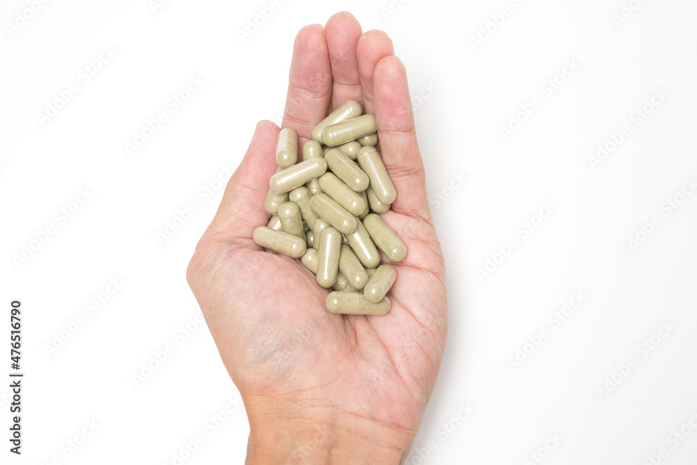 Selective focus of Many medicine capsules on hand on white background Selective focus of Many medicine capsules on hand on white background