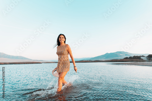 latin woman walking in the water smiling with dental braces happy