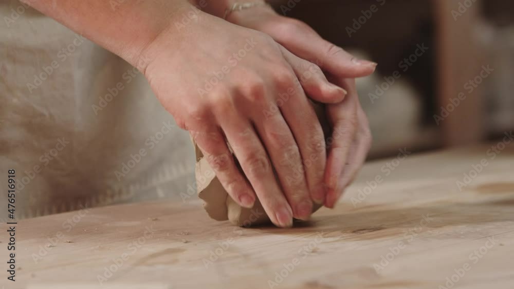 Pottery workshop - female hands kneading the clay Pottery workshop - female hands kneading the clay