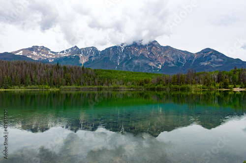 Fototapeta Naklejka Na Ścianę i Meble -  Patricia Lake in Jasper Alberta, clear water with reflection of Pyramid Mountain. White partially cloudy sky