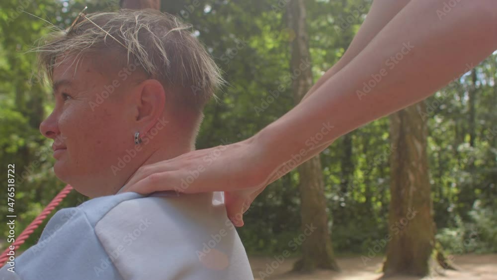 A social worker doing massage to a shoulders of disabled person. Close up. Relaxation and recovery program after injuries outdoors. A social worker doing massage to a shoulders of disabled person. Close up. Relaxation and recovery program after injuries outdoors.