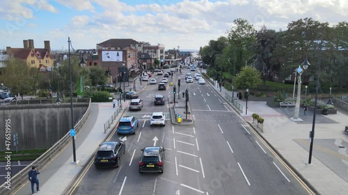 slowly driving cars of street in residential borough. Passing through crossroads. Woodford, London, UK