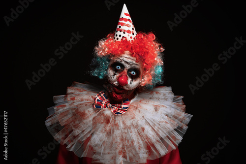 Fotografie Terrifying clown on black background. Halloween party costume