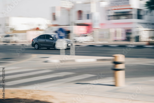 Fast-moving cars and delivery vans with a blurry background in Dubai street
