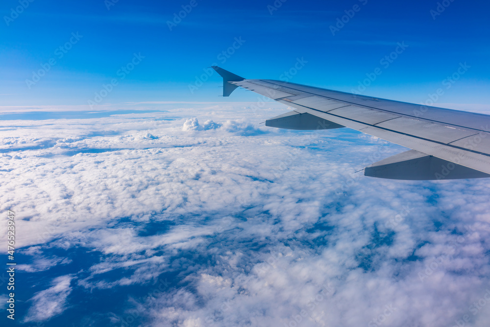 View from the airplane window at a beautiful cloudy sky and the airplane wing View from the airplane window at a beautiful cloudy sky and the airplane wing
