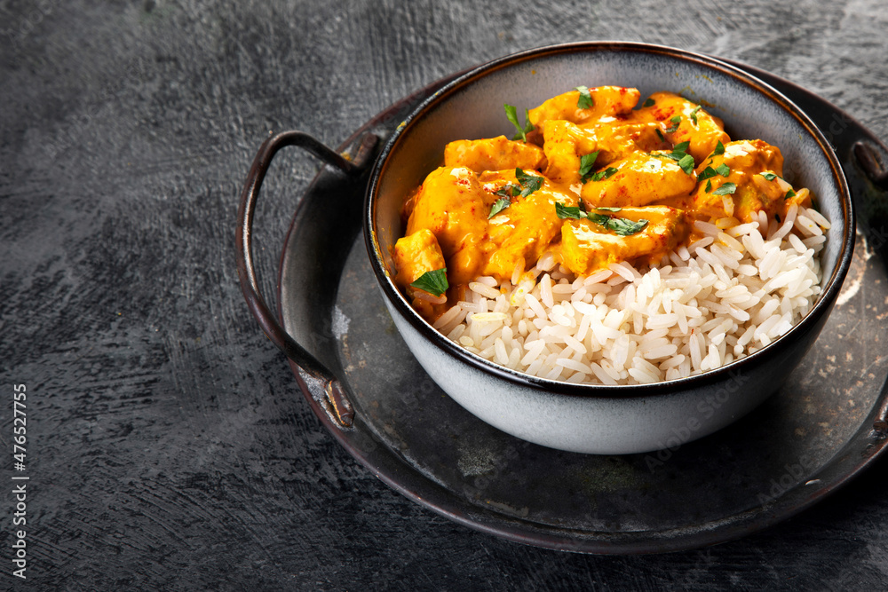 Indian butter chicken curry with basmati rice on dark background. Indian butter chicken curry with basmati rice on dark background.